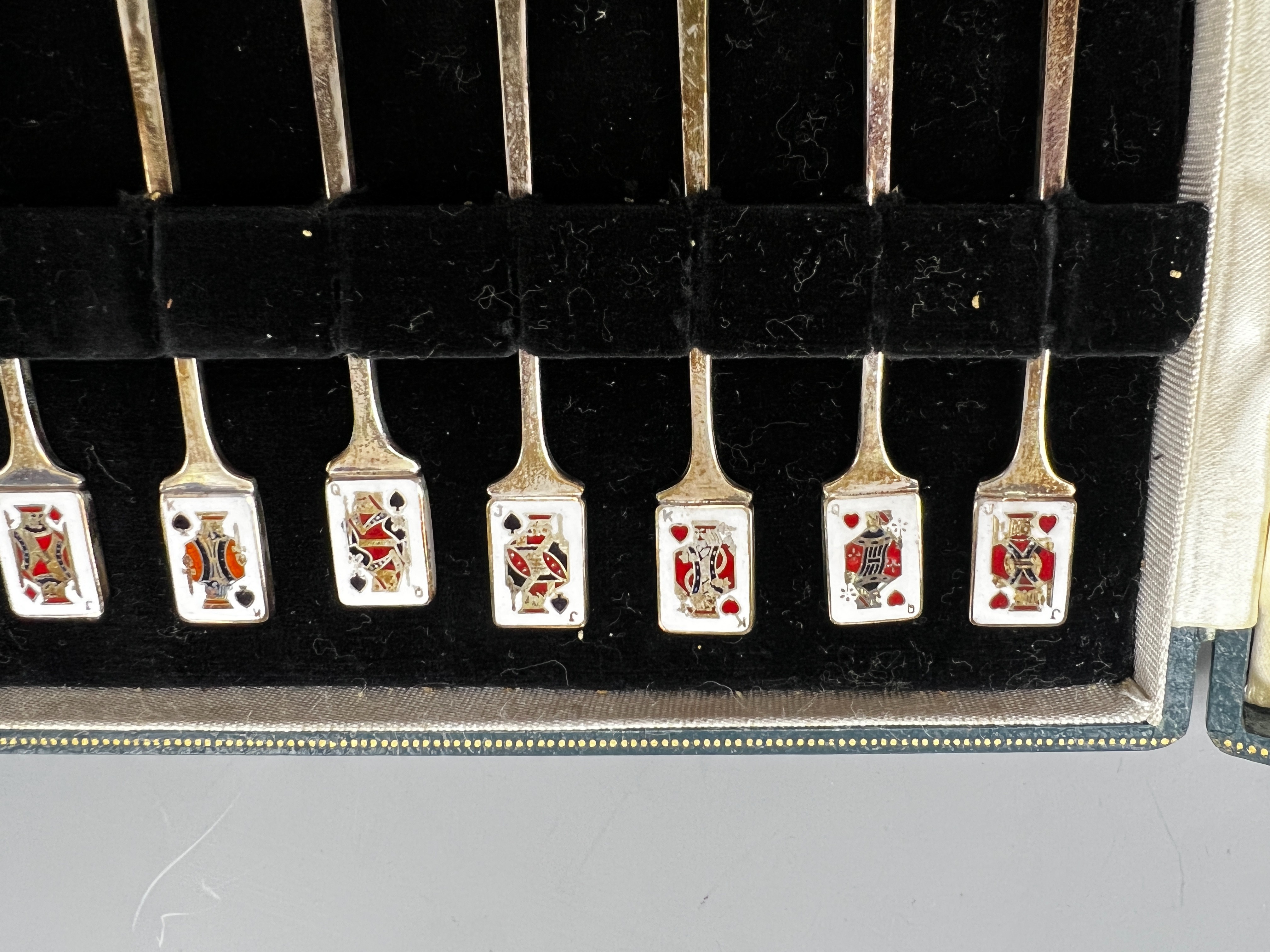 A cased set of twelve early 1960's silver and enamel cocktail sticks, by Garrard & Co, with playing card terminals, Birmingham, 1961.